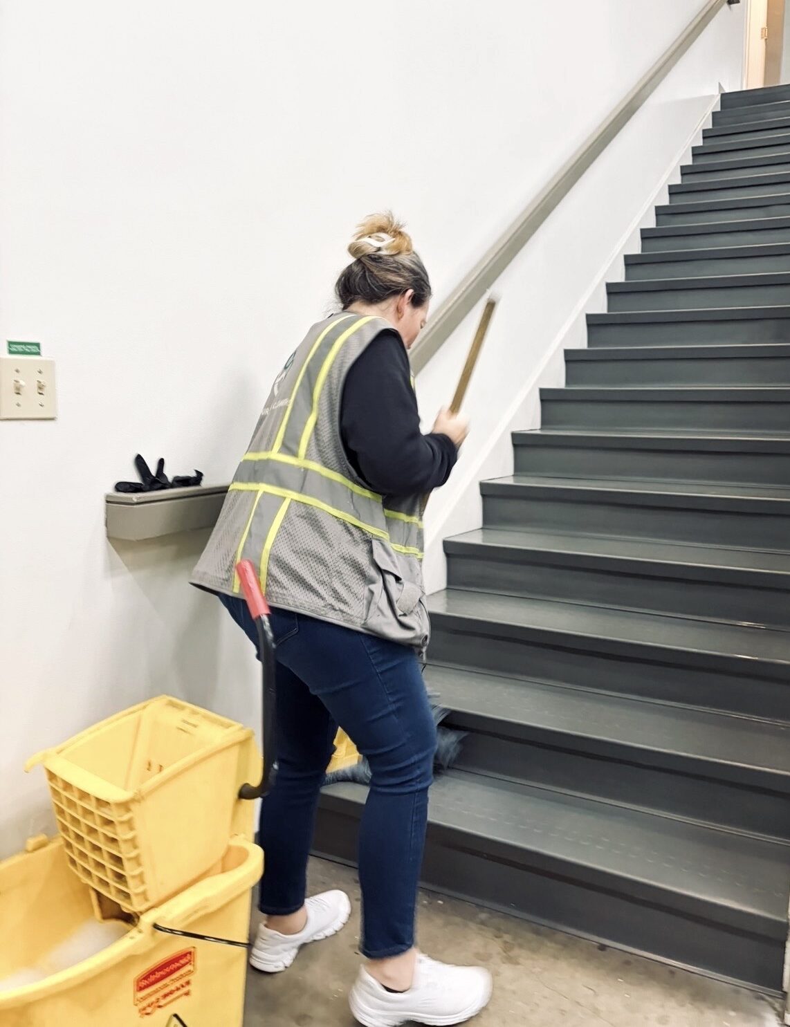 Office cleaner mopping stairs inside office building